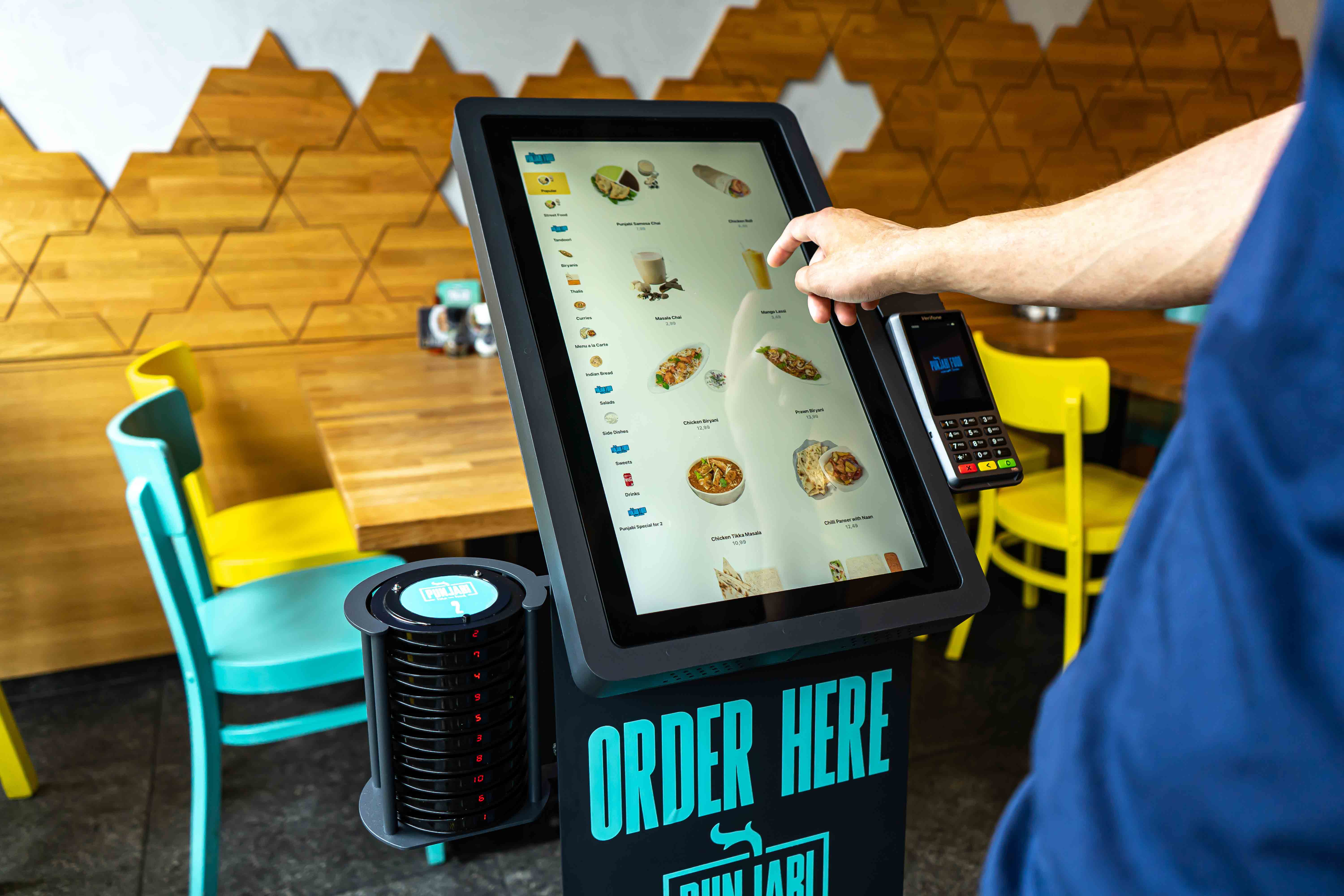 Foto van een bestelzuil, waarop een menu wordt weergegeven.